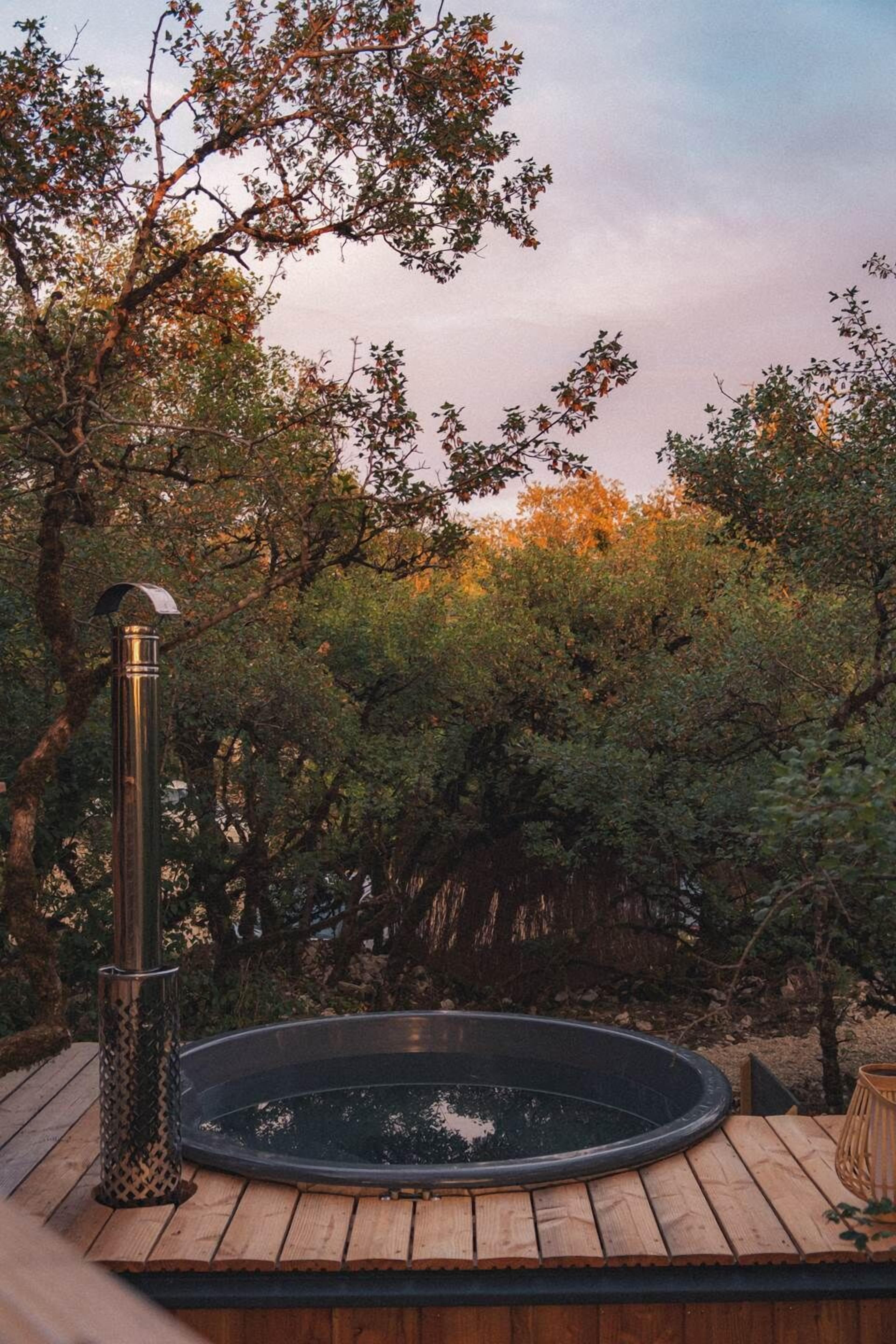 Ein Whirlpool auf einer Holterrasse, umgeben von Bäumen.