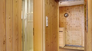 A wooden interior with a door leading to a room, a thermostat, and a circular wall decoration. - Apartment on the Main 1 with Private Terrace (Gemünden am Main)