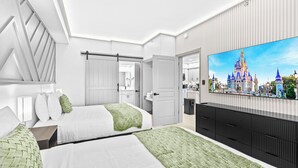 A modern hotel room with two beds, a large flat-screen TV, and a view of a castle. - 1 bedroom apartment near Disney and Universal (Orlando)