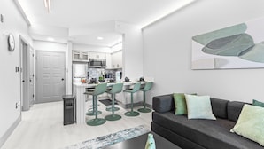 A modern apartment with a kitchen, dining area, and living room. - 1 bedroom apartment near Disney and Universal (Orlando)