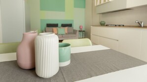 A modern kitchen with white cabinets, a grey countertop, and a green wall with geometric patterns. - BDC - Tender 2Bdr apartment @Navigli area (Milan)