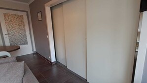 Ein Flur mit einer Schiebetür, ein Essbereich mit Tisch und Stühlen sowie eine Wand mit Muster.