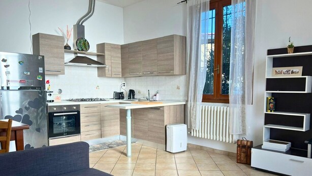 Eine moderne Küche mit Backofen, einer Kaffeemaschine und einem weißen Kühlschrank.