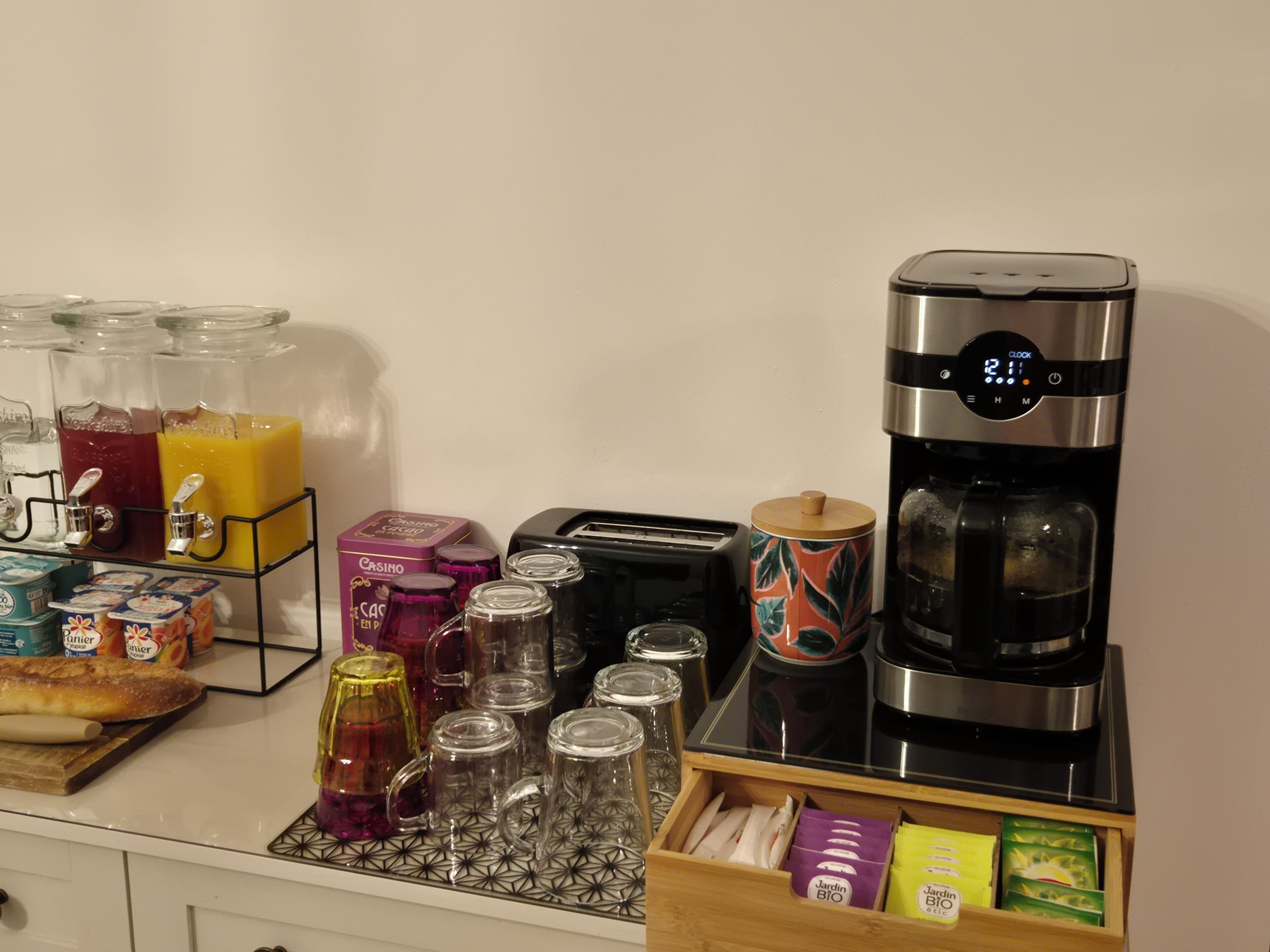 Eine Küchenzeile mit Kaffeemaschine, Toaster und verschiedenen Lebensmitteln.