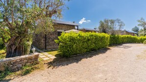 A stone building with a gravel driveway, surrounded by greenery and trees. - Apartment 'Core Resort - 1' with Wi-Fi and Air Conditioning (Tuglie)