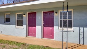 A single-story building with two red doors and a small window with blinds. - Huntsville Studio w/ Workspace Near Downtown (Huntsville)