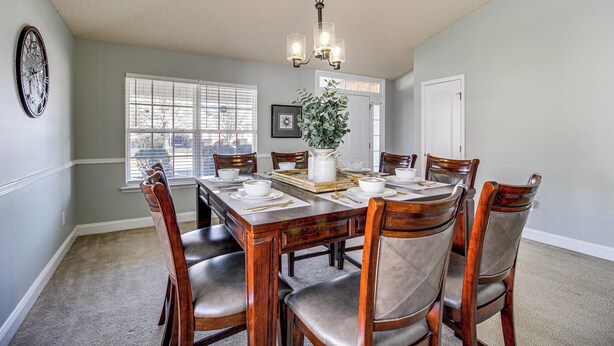 A dining room with a wooden table set for six, surrounded by six chairs. - Work-Friendly Madison Home Near Research Park (Madison)