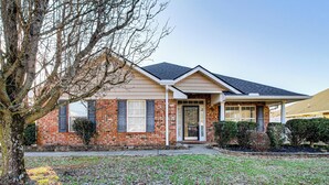 A two-story brick house with a front porch, a garage, and a well-maintained lawn. - Work-Friendly Madison Home Near Research Park (Madison)