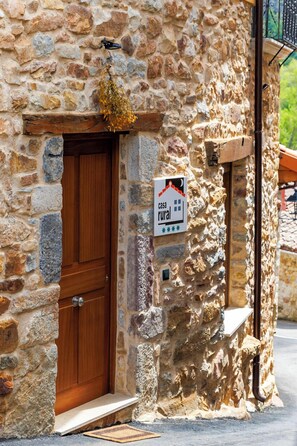 A rustic stone building with a wooden door and a sign indicating it is a rural house. -  El Refugio II de Verdiago Vive (Cremenes)