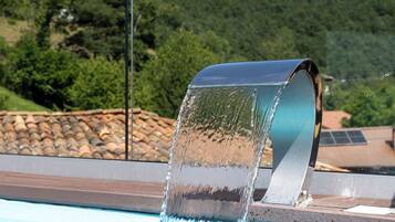 A swimming pool with a water feature.
