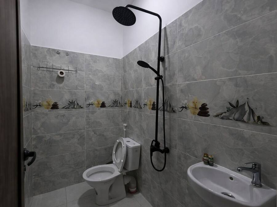 A bathroom with a shower, toilet, and sink.