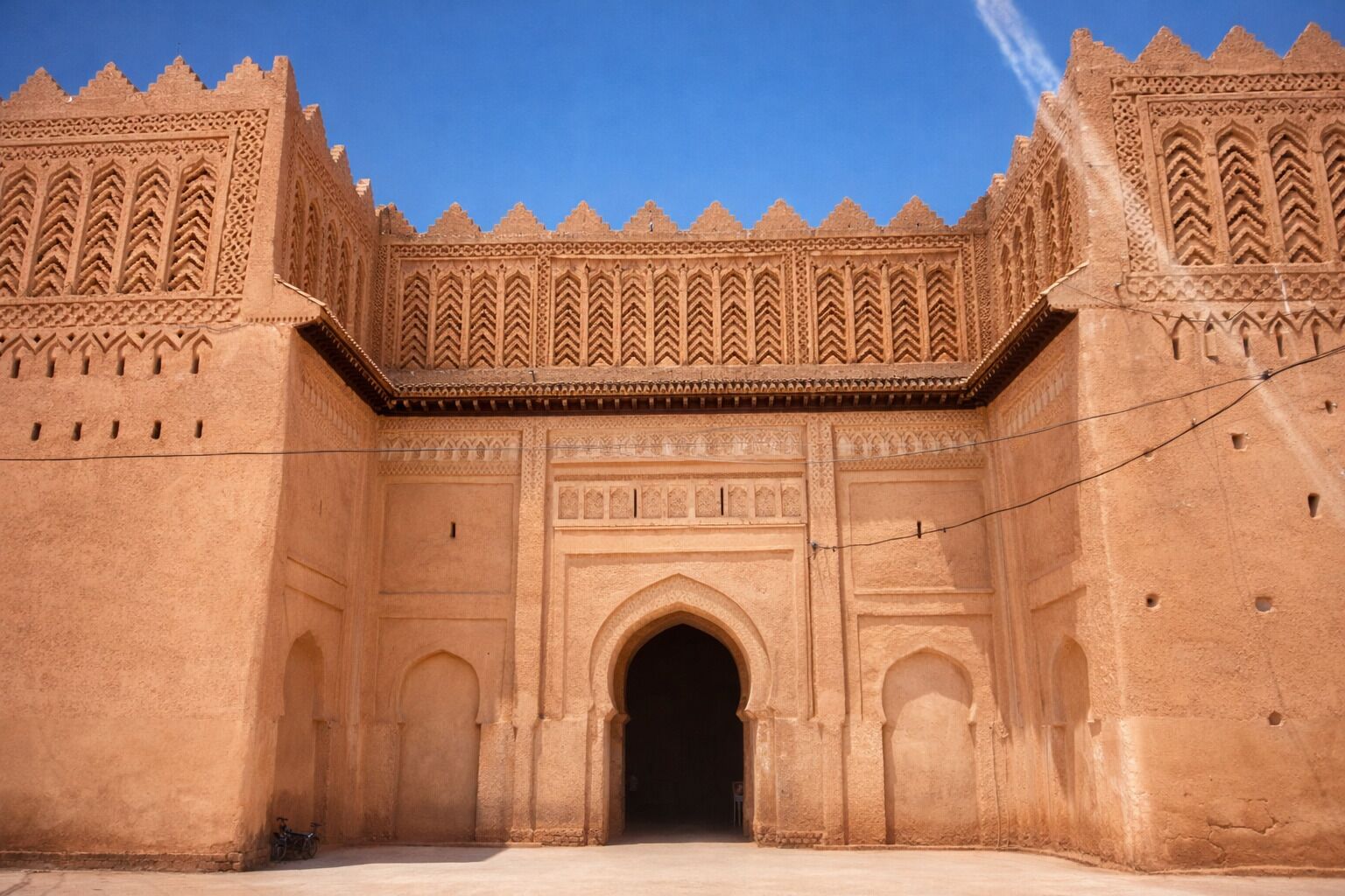 Ein großer, verschnörkelter Eingangsbereich mit aufwendigen Schnitzereien und einem zentralen Bogen.