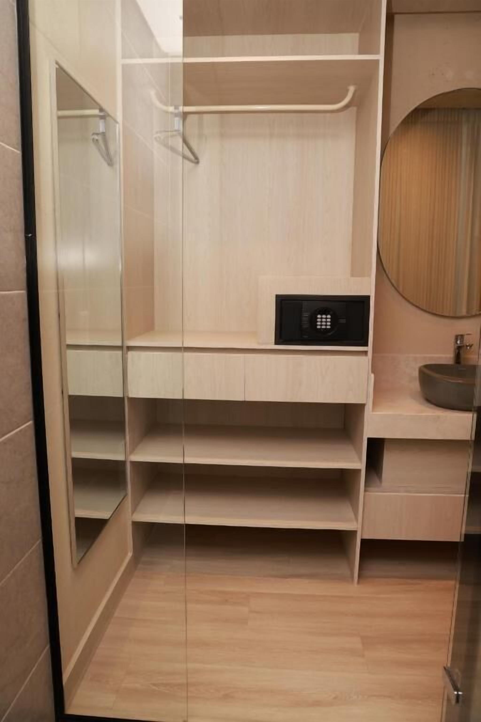 Een moderne badkamer met een glazen douchecabine, een ingebouwde wastafel met een wastafel en een spiegel.