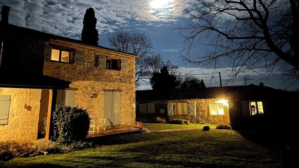 A stone house with a porch and a bench, under a night sky with a visible moon. - La Muse Rossignol: Swimming pool, spacious rooms & private bath in Occitanie (Belvèze)