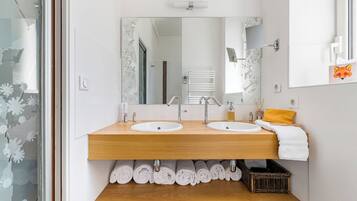 Un baño moderno con dos lavamanos, un espejo y un mueble de tocador de madera.
