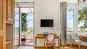 Ein modernes Schlafzimmer mit einem Holztisch, einem Stuhl, einem Bett und einem an der Wand befestigten Fernseher.