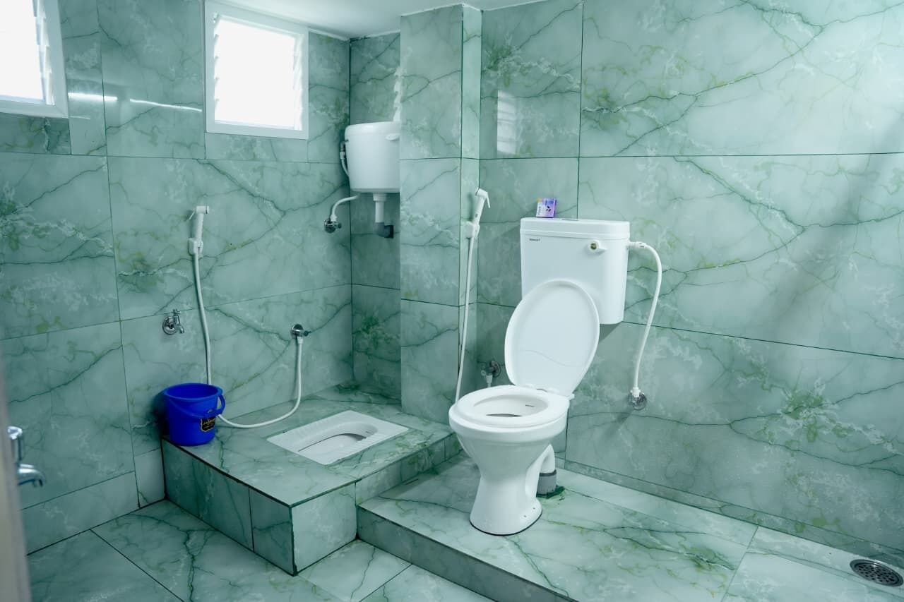 A bathroom with a toilet, bidet, and shower.
