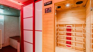 Un cuarto de sauna con un banco de madera, un panel de control y una pared con azulejos.