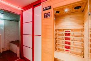 Un sauna avec un banc en bois, un panneau de commande et un mur recouvert de carreaux.