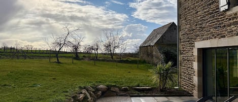 Una casa de piedra con un patio y mobiliario para exteriores.