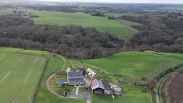 An aerial view of a rural property with a large house surrounded by fields and trees.