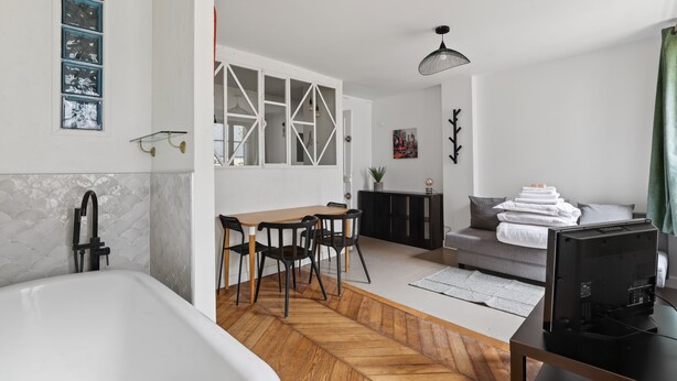 Un espacio habitable moderno con cocina, comedor y dormitorio.