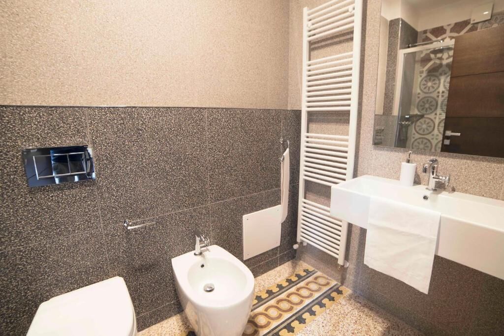Een badkamer met een toiletbril, een wastafel en een handdoekhouder.