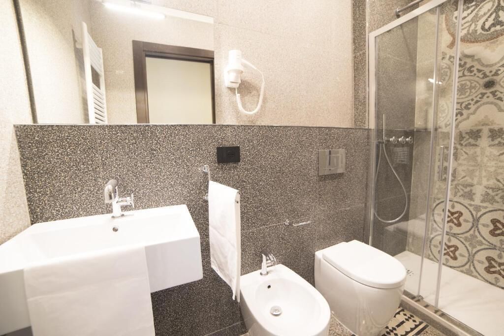Un baño moderno con un lavabo blanco, un bidé y un inodoro.