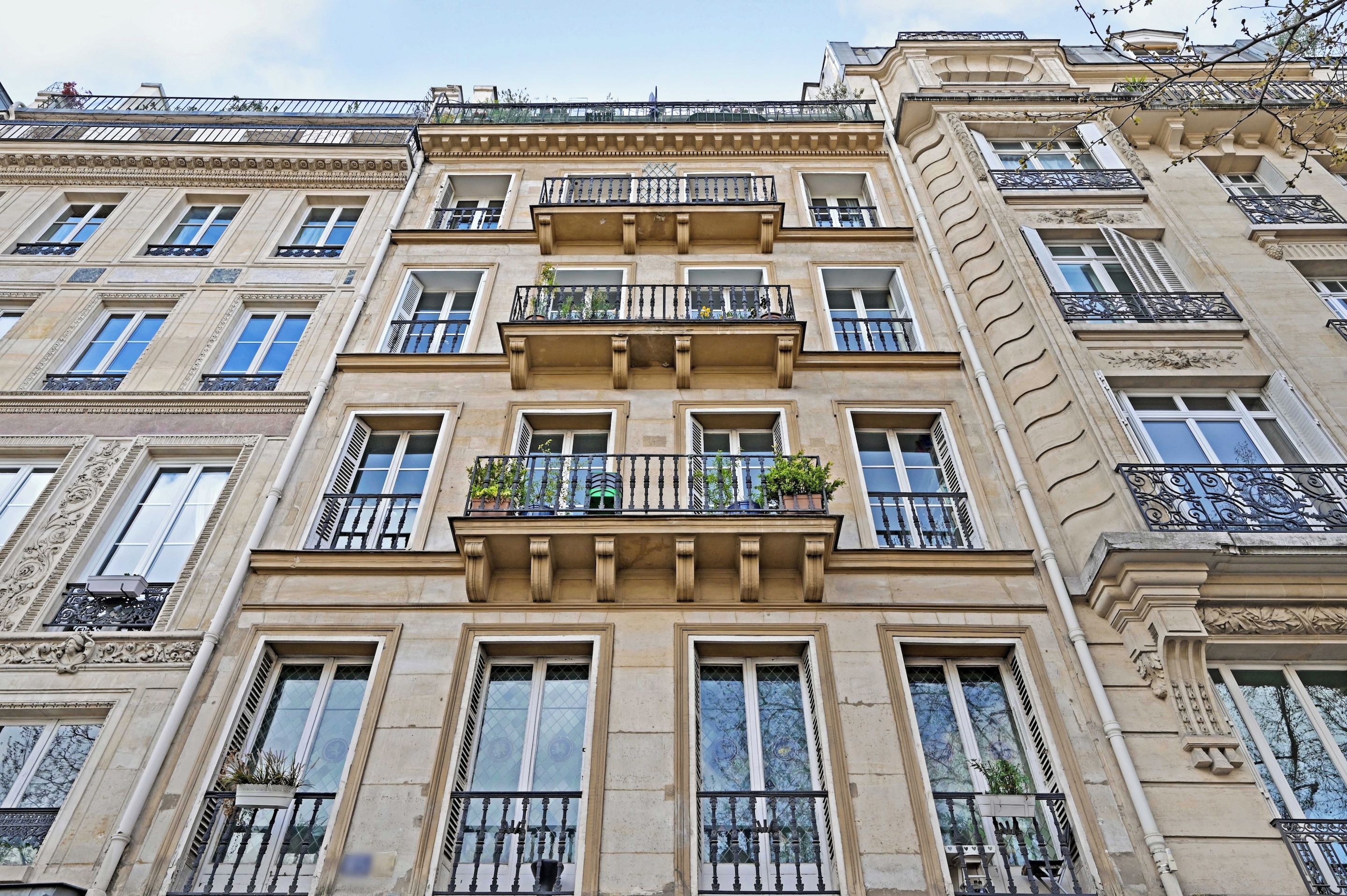 A multi-story building with balconies, large windows, and classical architectural details.