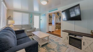A living room with a sofa, coffee table, fireplace, and a TV mounted on the wall. - 2877 Crater Lake - Sleeps 8 (Myrtle Beach)