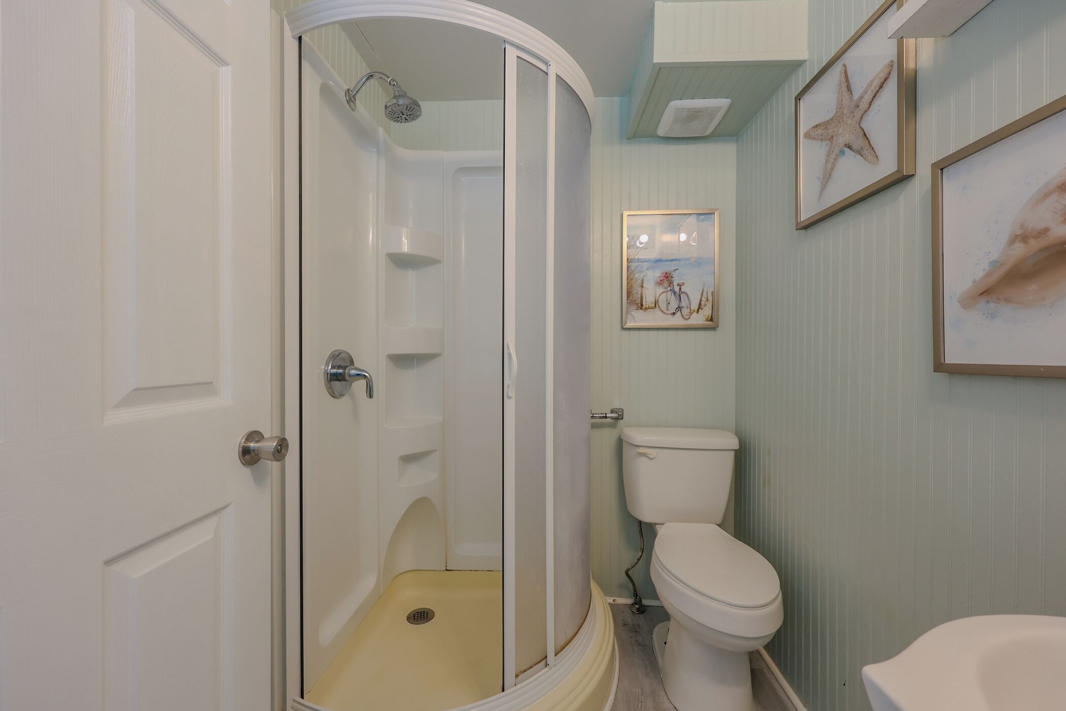 A bathroom with a walk-in shower, toilet, and sink.