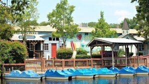 A lakeside scene with boats, a building labeled "APOTHECARY," and a mural with "I Love Lake" text. - 2877 Crater Lake - Sleeps 8 (Myrtle Beach)