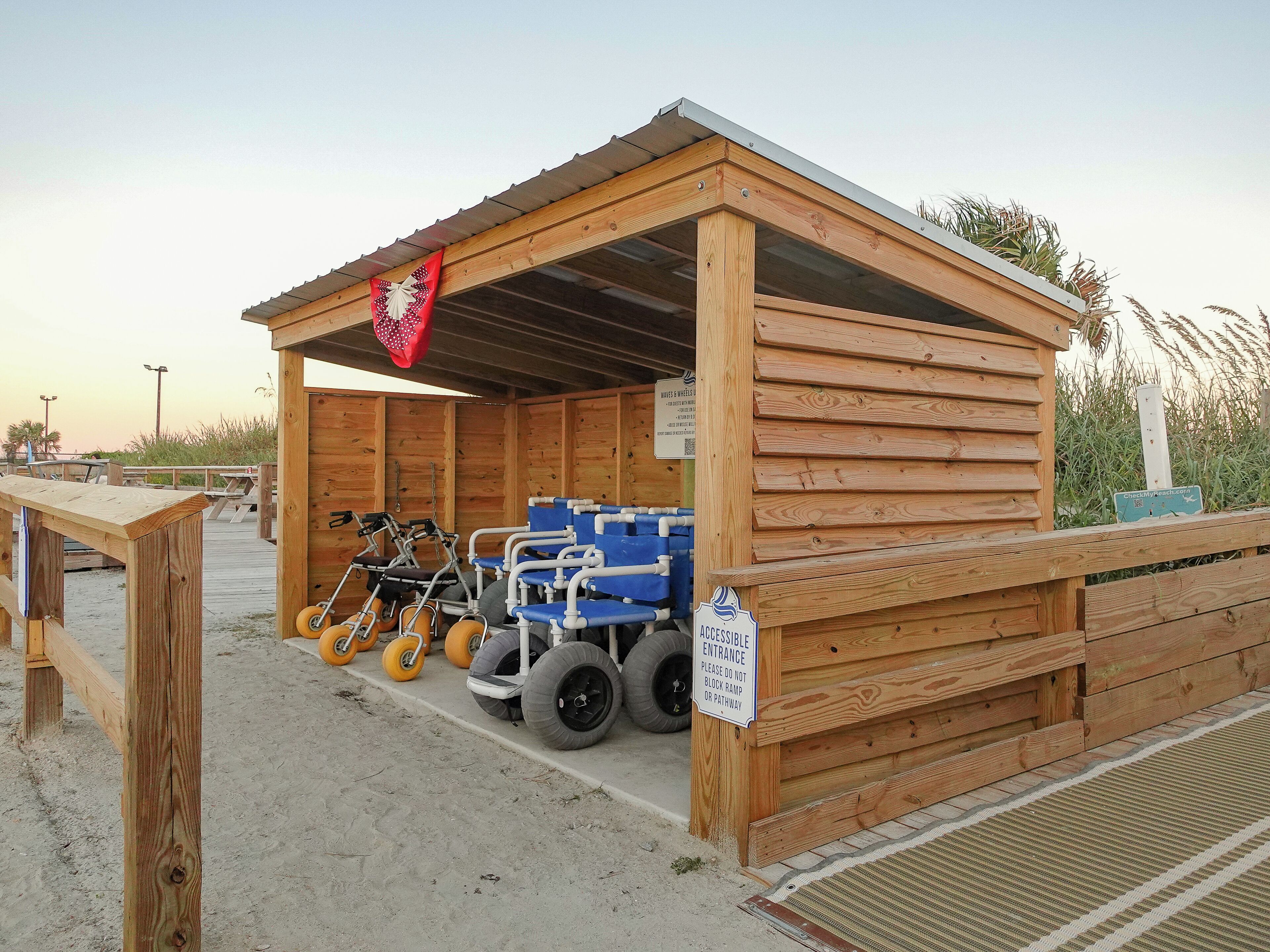 Une structure en bois dotée d’une rampe et d’une entrée accessible aux personnes en fauteuil roulant.