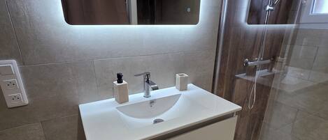 Secadora de cabello, toallas, jabón, papel de baño