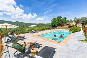 A pool area with lounge chairs and umbrellas, surrounded by greenery and hills. - Adults Only Rural | 2 P | Pool | WiFi| BBQ| Girona (Madremanya)