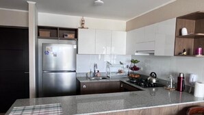 Een moderne keuken met een roestvrijstalen koelkast, een inbouwoven en een granieten aanrecht.