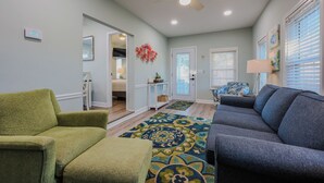 A living room with a green armchair, a gray sofa, and a patterned rug. - 8143 Seascape Deluxe- Sleeps 8 (Myrtle Beach)