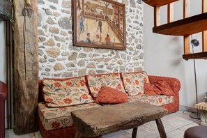 A stone wall, a wooden bench, and a sofa with floral upholstery.