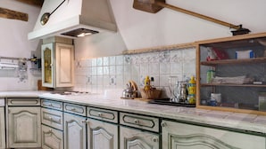 A kitchen with a large island, wooden cabinets, and a tiled backsplash. - Holiday Home 'Les Trois Maisons - Gite Vert' with Mountain View, Shared Pool and Wi-Fi (Osse-en-Aspe)