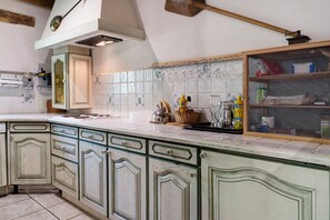 A kitchen with a large island, wooden cabinets, and a tiled backsplash. - Holiday Home 'Les Trois Maisons - Gite Vert' with Mountain View, Shared Pool and Wi-Fi (Osse-en-Aspe)