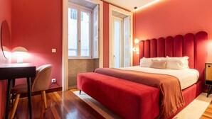 A hotel room with a large bed, a desk, and a chair. There is a window with a view of the outside. - Myo Design House: São Bento (Porto)