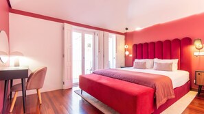 Ein Schlafzimmer mit Bett, Schreibtisch, Stuhl und einer Tür zu einem Außenbereich.