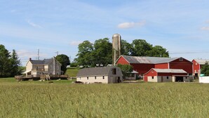 Un paysage rural avec un grand silo à céréales, une grange rouge et une ferme.