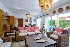 A spacious living area with wicker furniture, a wooden coffee table, and a decorative chandelier. - ®2BR{Beach~Spot} @Terrenas+Jaccuzi+Walk~to~Beach (El Limón)