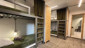 Un dormitorio moderno, de varios niveles, con literas, estantes empotrados y suelo de madera.