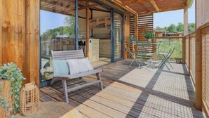 A wooden deck with a bench, a table, and chairs.
