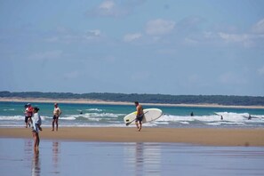 Ein Strand mit Menschen und einem Surfbrett.