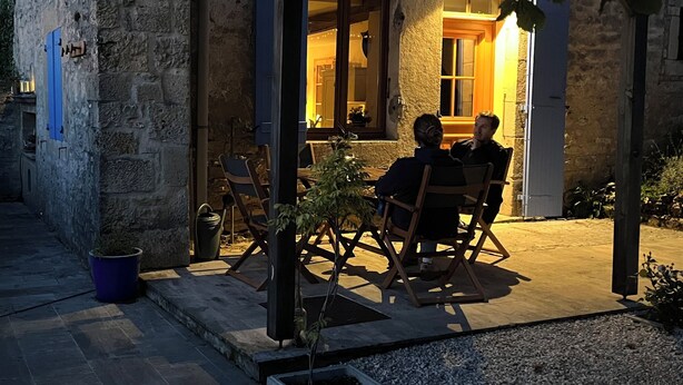 A stone building with a covered patio area featuring two wooden chairs and a small table. - Charming country house with a Scandinavian bath outside. Dogs welcome! (Magny-Lambert)