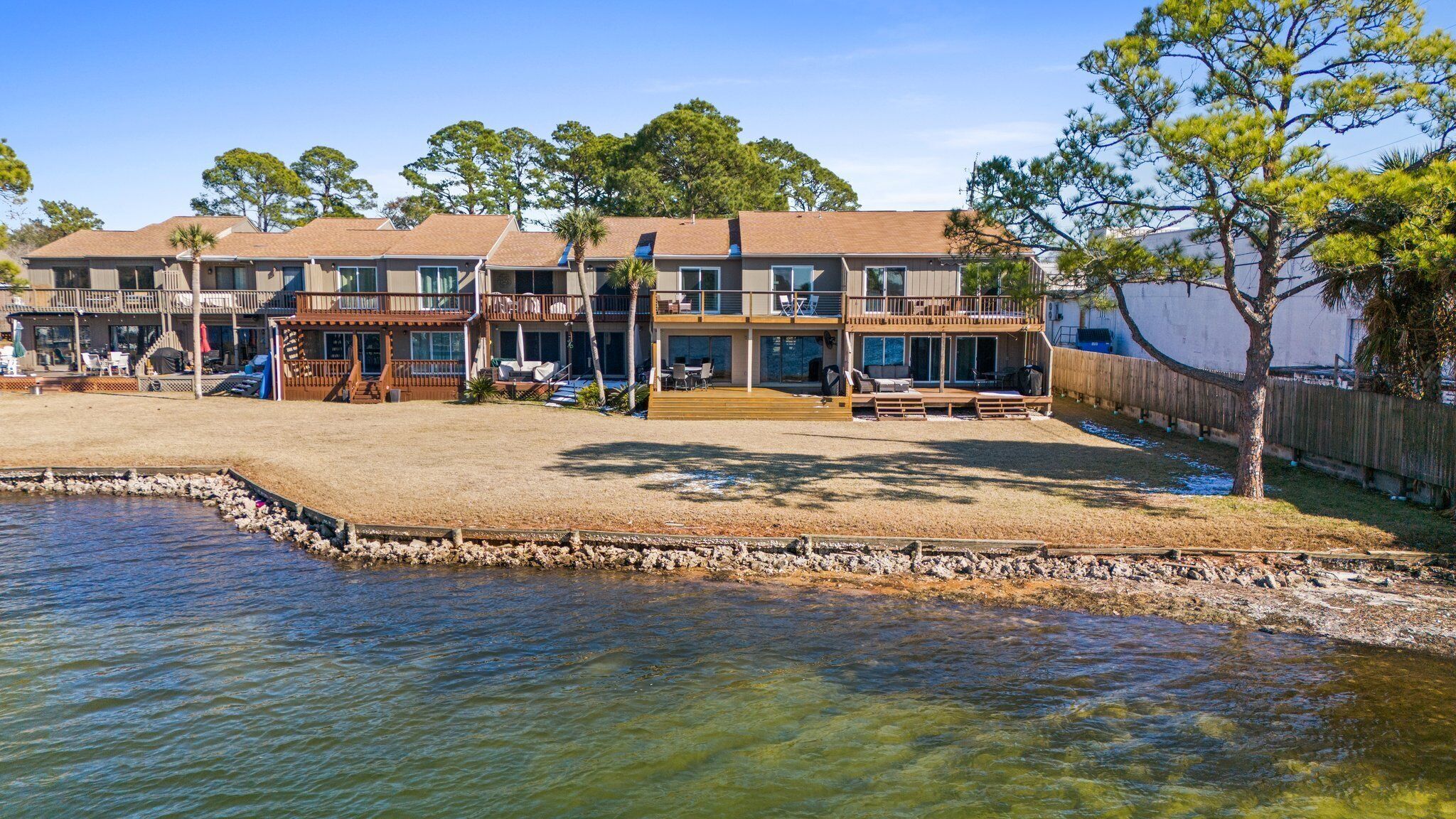 A two-story house with a large deck and outdoor seating area.