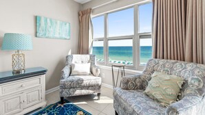 A room with a view of the ocean, a patterned armchair, a side table, and a lamp. - Beach Front, "Resting Beach Face” 4006 Free Activities Included (Fort Walton Beach)